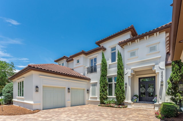 mediterranean / spanish home with french doors and a garage