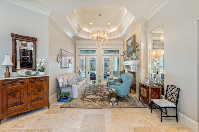 sitting room featuring french doors, ornamental molding, a raised ceiling, a notable chandelier, and a fireplace