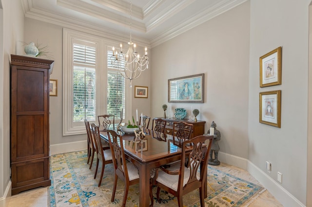 dining room featuring a notable chandelier, a raised ceiling, and ornamental molding