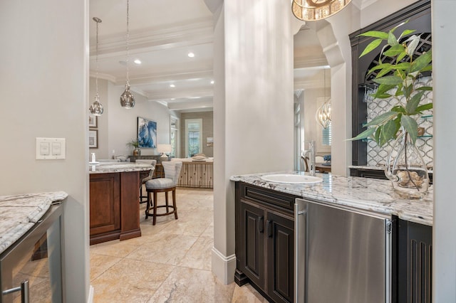 interior space featuring a kitchen breakfast bar, ornamental molding, dark brown cabinetry, sink, and beamed ceiling