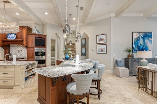 kitchen featuring a large island, sink, pendant lighting, and ornamental molding