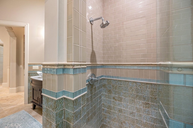 bathroom with tile patterned flooring, vanity, a shower, and tile walls