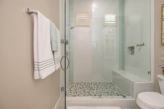 bathroom with an enclosed shower and toilet