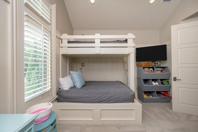 bedroom featuring light colored carpet and lofted ceiling