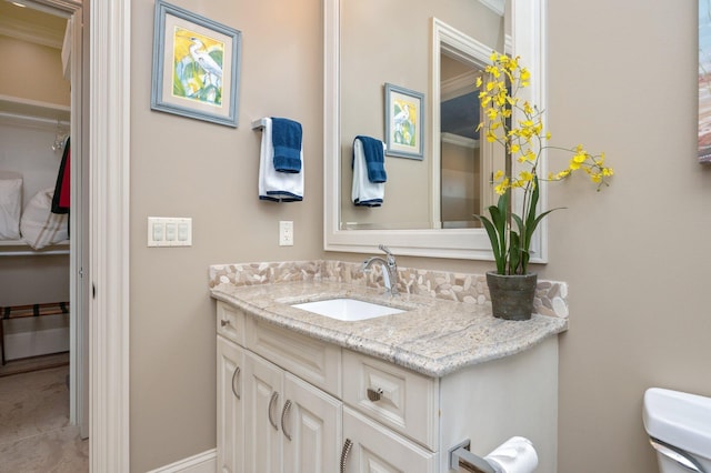 bathroom featuring vanity, toilet, and crown molding