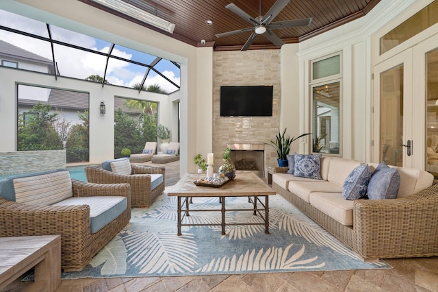 sunroom / solarium featuring ceiling fan, a large fireplace, and wood ceiling