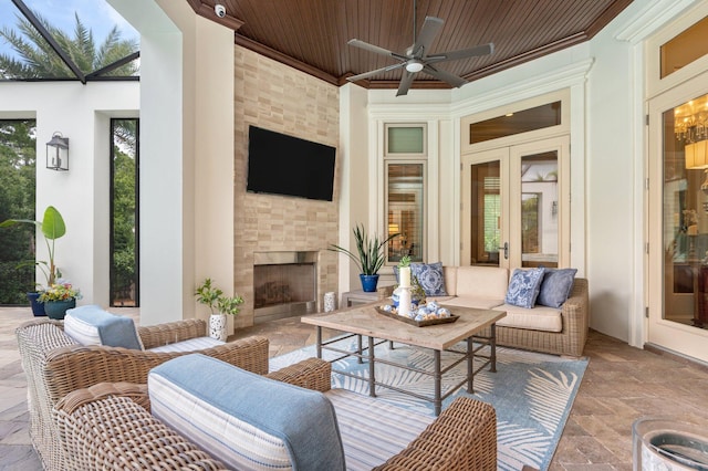 view of patio with an outdoor living space with a fireplace and ceiling fan