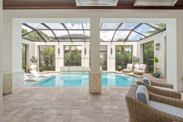 view of pool with pool water feature, glass enclosure, an outdoor hangout area, and a patio