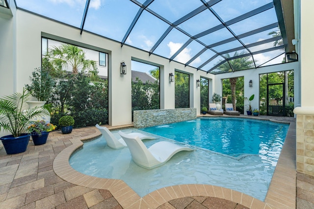 view of pool featuring pool water feature, a lanai, and a patio