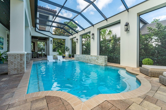 view of pool with a lanai, a patio area, and pool water feature