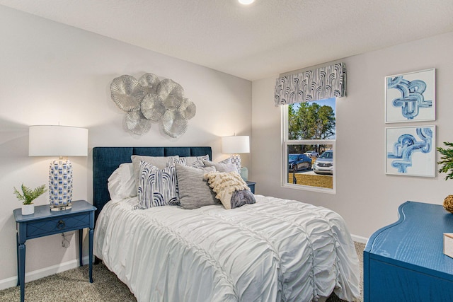 bedroom with a textured ceiling, baseboards, and carpet flooring