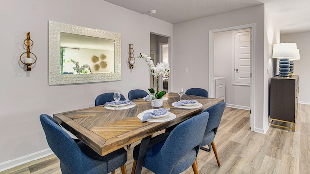 dining area with light wood-style floors and baseboards