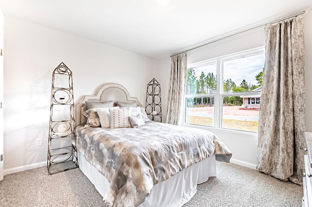 bedroom featuring light carpet and baseboards