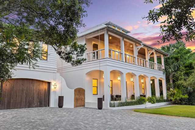 view of front facade featuring a garage and a balcony