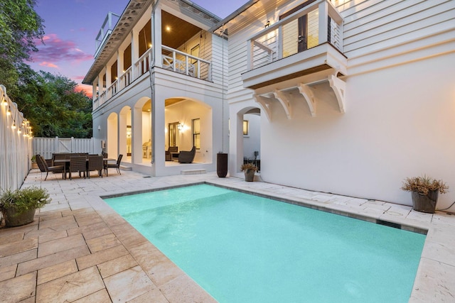 pool at dusk with a patio