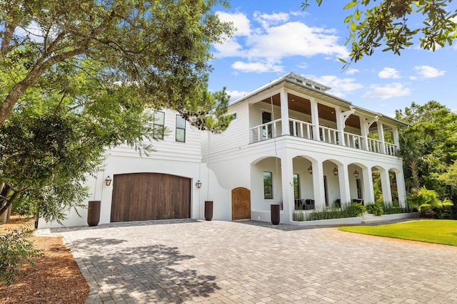 view of front of property featuring a garage and a balcony