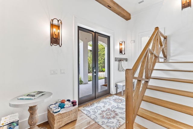 doorway with french doors, hardwood / wood-style flooring, and beamed ceiling