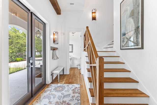 entryway with light hardwood / wood-style flooring, french doors, and beamed ceiling