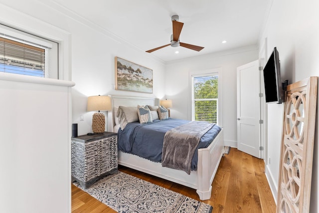 bedroom with hardwood / wood-style flooring, ornamental molding, and ceiling fan