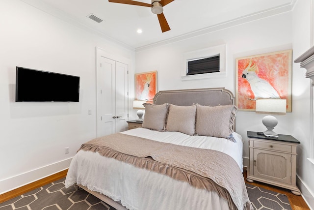 bedroom featuring ornamental molding, dark hardwood / wood-style floors, ceiling fan, and a closet