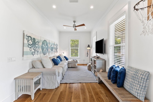 living room with hardwood / wood-style flooring, ornamental molding, and ceiling fan