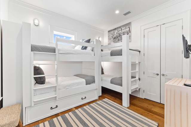 bedroom featuring crown molding and dark hardwood / wood-style floors