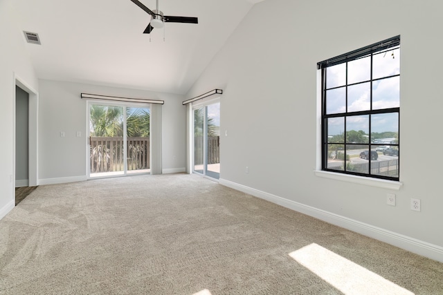 carpeted empty room with high vaulted ceiling and ceiling fan