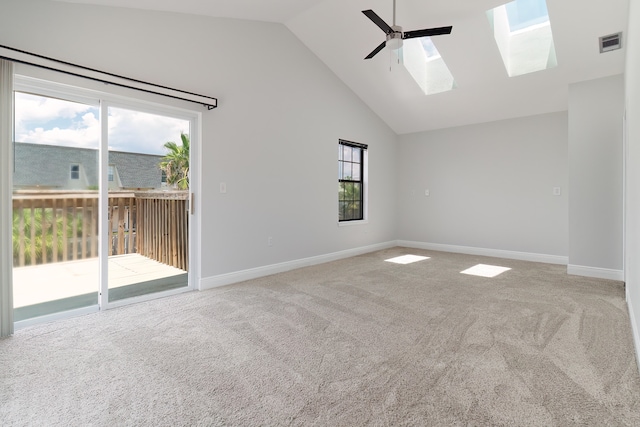 empty room featuring a skylight, carpet, high vaulted ceiling, and ceiling fan