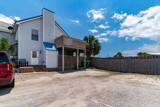 356 Billfish Ave Unit 8, Fort Walton Beach, FL 32548 - view of home's exterior with fence, a wooden deck, and a chimney
