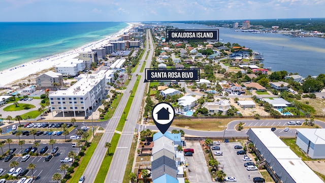 birds eye view of property with a water view and a beach view