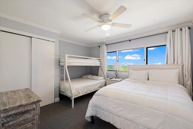 carpeted bedroom with ornamental molding, a closet, and ceiling fan