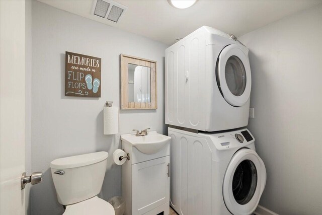 washroom with sink and stacked washer and clothes dryer