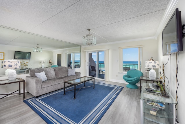 living room featuring hardwood / wood-style flooring, a notable chandelier, and crown molding