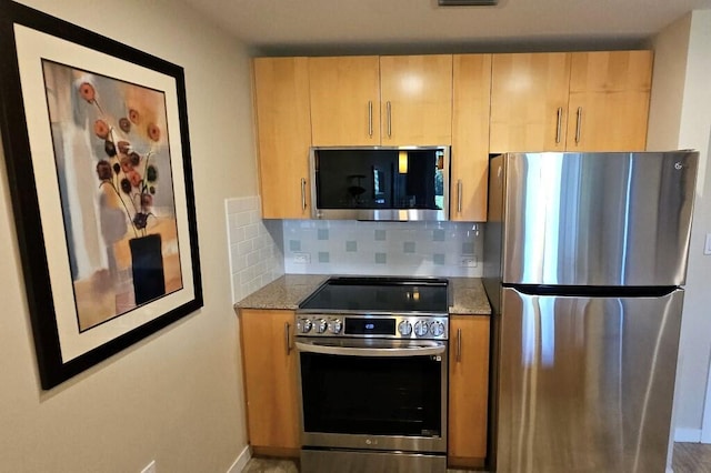 kitchen featuring decorative backsplash, appliances with stainless steel finishes, light brown cabinets, and light stone counters