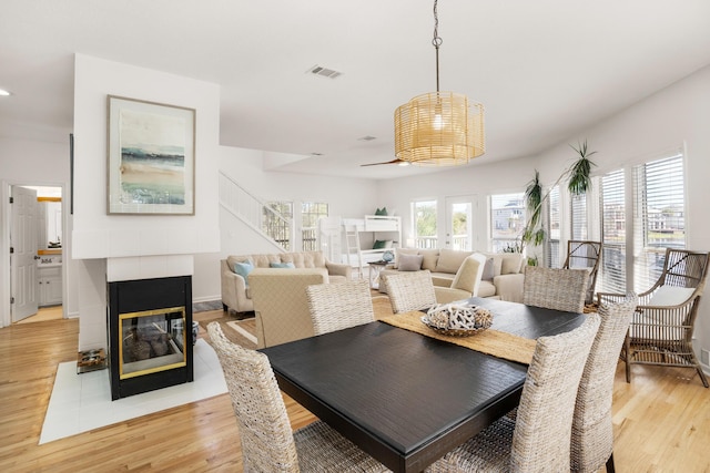 dining space with light hardwood / wood-style flooring and a tiled fireplace