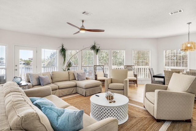 living room with ceiling fan, light hardwood / wood-style floors, and a wealth of natural light