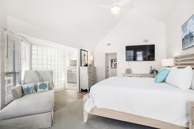 bedroom with ensuite bathroom, high vaulted ceiling, ceiling fan, and light hardwood / wood-style floors