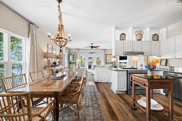 dining space featuring french doors, dark wood-type flooring, and ceiling fan with notable chandelier