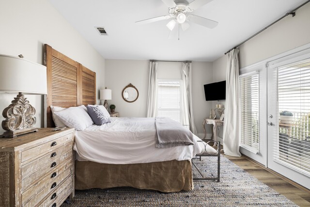 bedroom with access to exterior, ceiling fan, and dark wood-type flooring