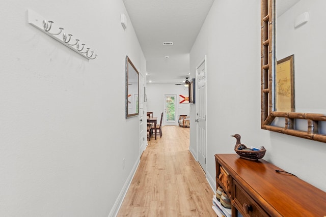 corridor with light hardwood / wood-style floors