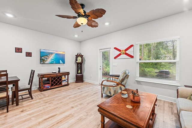 living room with light hardwood / wood-style flooring and ceiling fan