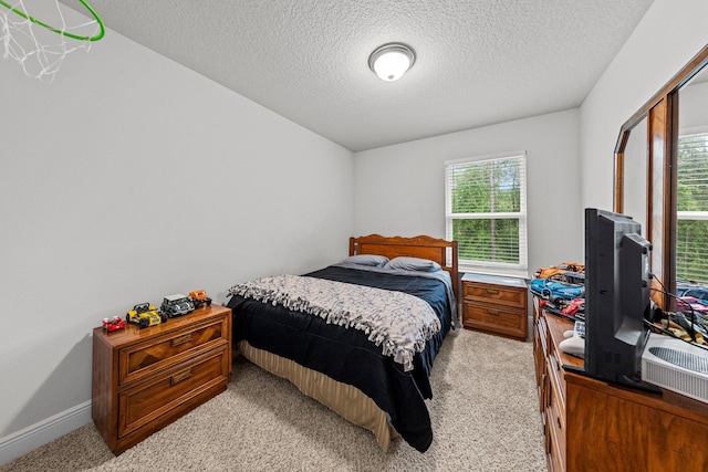 bedroom featuring light carpet and a textured ceiling