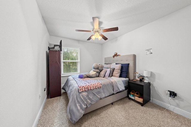 bedroom featuring ceiling fan, a textured ceiling, and light carpet