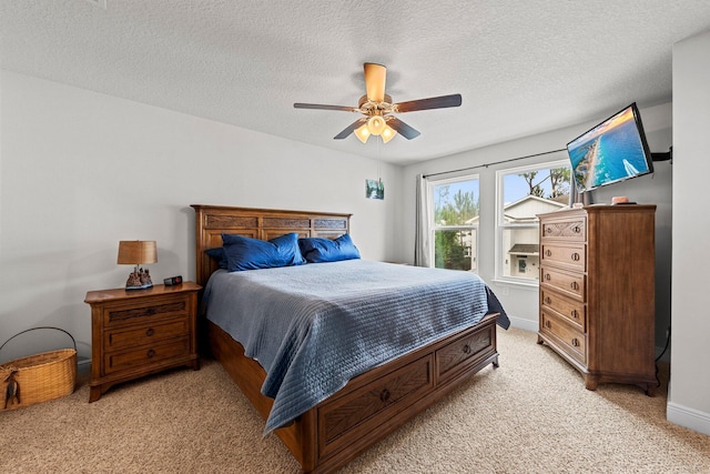 carpeted bedroom featuring ceiling fan and a textured ceiling