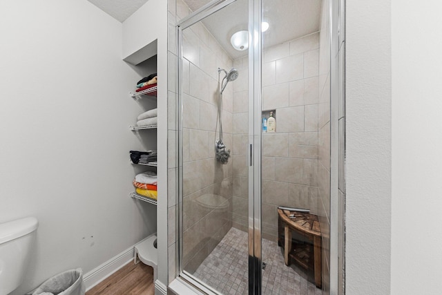 bathroom with a shower with door, wood-type flooring, and toilet