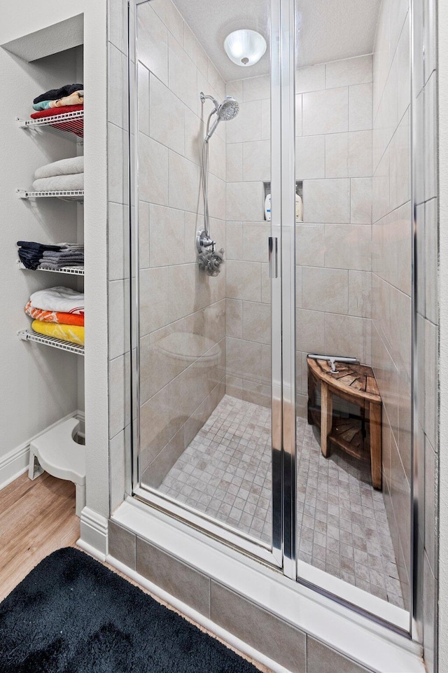 bathroom featuring an enclosed shower and wood-type flooring