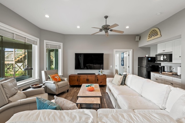 living room with ceiling fan and dark wood-type flooring