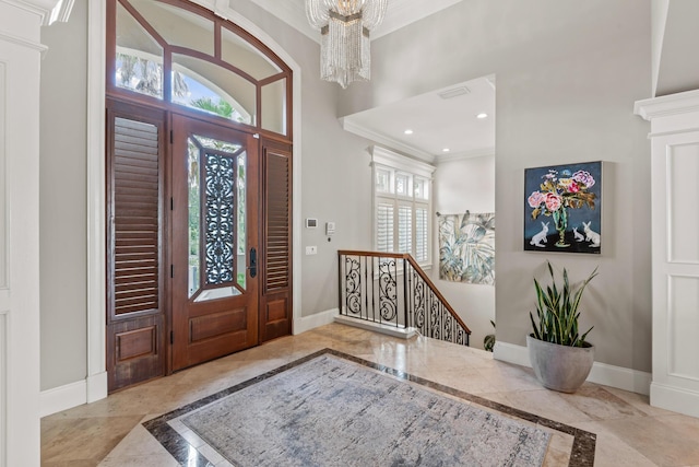 entryway featuring ornamental molding and an inviting chandelier