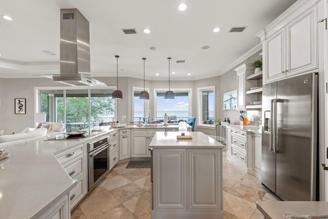 kitchen featuring kitchen peninsula, island exhaust hood, hanging light fixtures, stainless steel appliances, and white cabinets