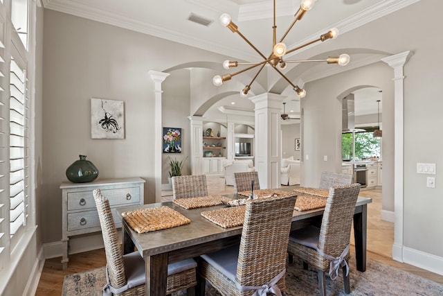 dining space with ornate columns, ornamental molding, and hardwood / wood-style floors